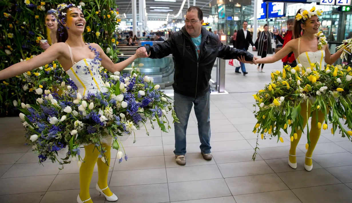 Model menyapa wisatawan saat berlangsungnya pameran bunga Keukenhof di Central Station di Utrecht, Belanda, (29/3). Pameran ini menghadirkan sekitar 20.000 bunga musim semi. (AP Photo / Peter Dejong)