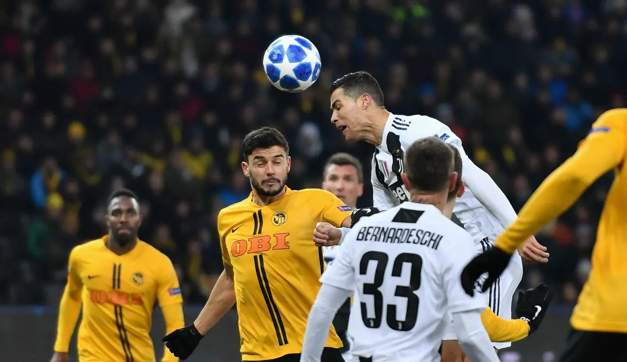 Aksi Cristiano Ronaldo melakukan duel udara kontra Young Boys pada laga lanjutan Liga Champions yang berlangsung di stadion Stade de Suisse, Swiss, Kamis (13/12). Juventus kalah 1-2 atas Young Boys. (AFP/Fabrice Coffrini)