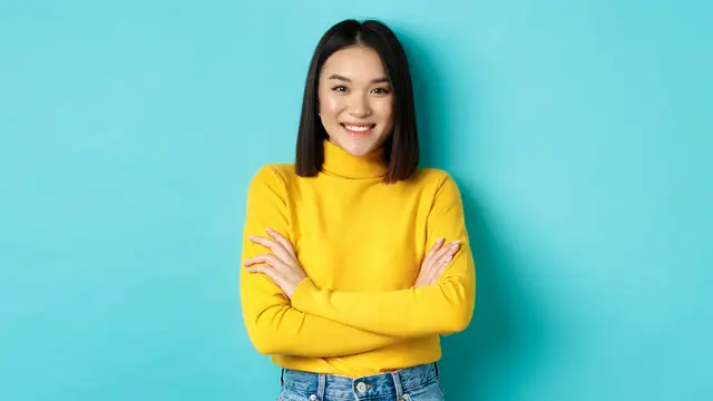 Seorang perempuan berbaju kuning sedang menyilangkan tangannya (Foto Dok: Freepik/benzoix)