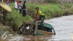 Prajurit Kostrad TNI AD memeriksa bangkai mobil yang diduga terdapat jenazah korban musibah banjir bandang di Cimacan, Garut (23/9). Data terakhir, korban jiwa mencapai 26 orang dan warga yang dilaporkan hilang 23 orang. (Liputan6.com/Johan Tallo)