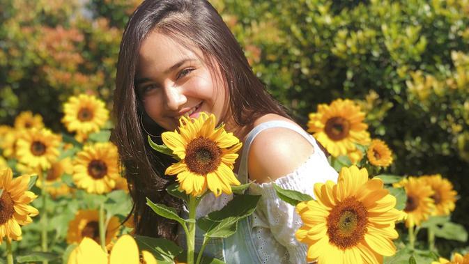 Senyum manis perempuan yang dekat dengan Rizky Nazar juga begitu terpancarkan. Senyum manisnya ini dipuji netizen cantik menawan. Berfoto di taman bunga matahari membuatnya terlihat tampak begitu cerah. (Liputan6.com/IG/@syifahadjureal)