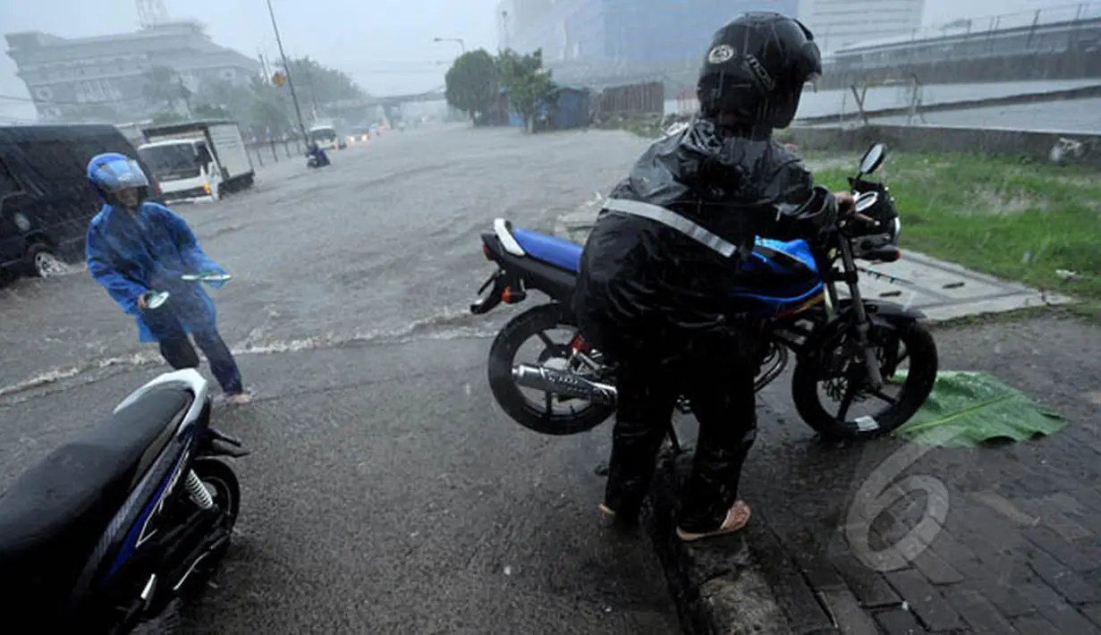Seorang pengendara motor memutar balik untuk menghindari banjir di jalan Gunung Sahari, Jakarta, Senin (9/2/2015).  (Liputan6.com/Faizal Fanani)