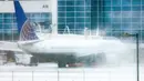 Sebuah pesawat United Airlines terparkir di gerbang selama badai musim dingin di Bandara Internasional Denver di Denver, Colorado, Rabu (22/2/2023). Selain mambatalkan penerbangan, badai musim dingin yang besar menghantam Northern Plains dan Upper Midwest dengan angin kencang dan salju lebat pada hari Rabu yang memaksa ratusan sekolah tutup. (Michael Ciaglo/Getty Images/AFP)