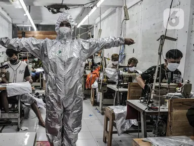 Pekerja mencoba baju hazmat setelah selesai dibuat di salah satu industri konveksi Pusat Industri Kecil (PIK), Jakarta, Rabu (30/12/2020). Budi (48), seorang marketing di Toko Konveksi Baju, mengungkapkan permintaan baju hazmat hingga kini masih tinggi. (merdeka.com/Iqbal S. Nugroho)
