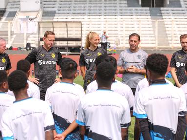 Direktur Papua Football Academy, Wofgang Pikal (kedua kanan) ditemani tiga legenda Borussia Dortmund, Paul Lambert (kiri), Joerg Heinrich (kedua kiri), dan Marcel Schmelzer (kanan) memberikan sambutan kepada peserta coaching clinic yang berlangsung di Stadion Madya, Senayan, Jakarta, Jumat (08/09/2023). (Bola.com/Bagaskara Lazuardi)