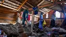 Ratusan kepala keluarga yang menjadi korban bencana banjir bandang dan tanah longsor di Kabupaten Pidie Jaya, Aceh, hingga kini masih harus bertahan di tenda-tenda darurat. Tampak dalam foto, korban selamat banjir Rauzah (kiri), seorang ibu empat anak, menyelamatkan barang-barang dari rumahnya yang rusak di Meurah Dua, Kabupaten Pidie Jaya, Provinsi Aceh, pada 21 Februari 2026, setelah banjir dan tanah longsor dahsyat melanda Sumatra, akhir November 2025 lalu. (CHAIDEER MAHYUDDIN/AFP)