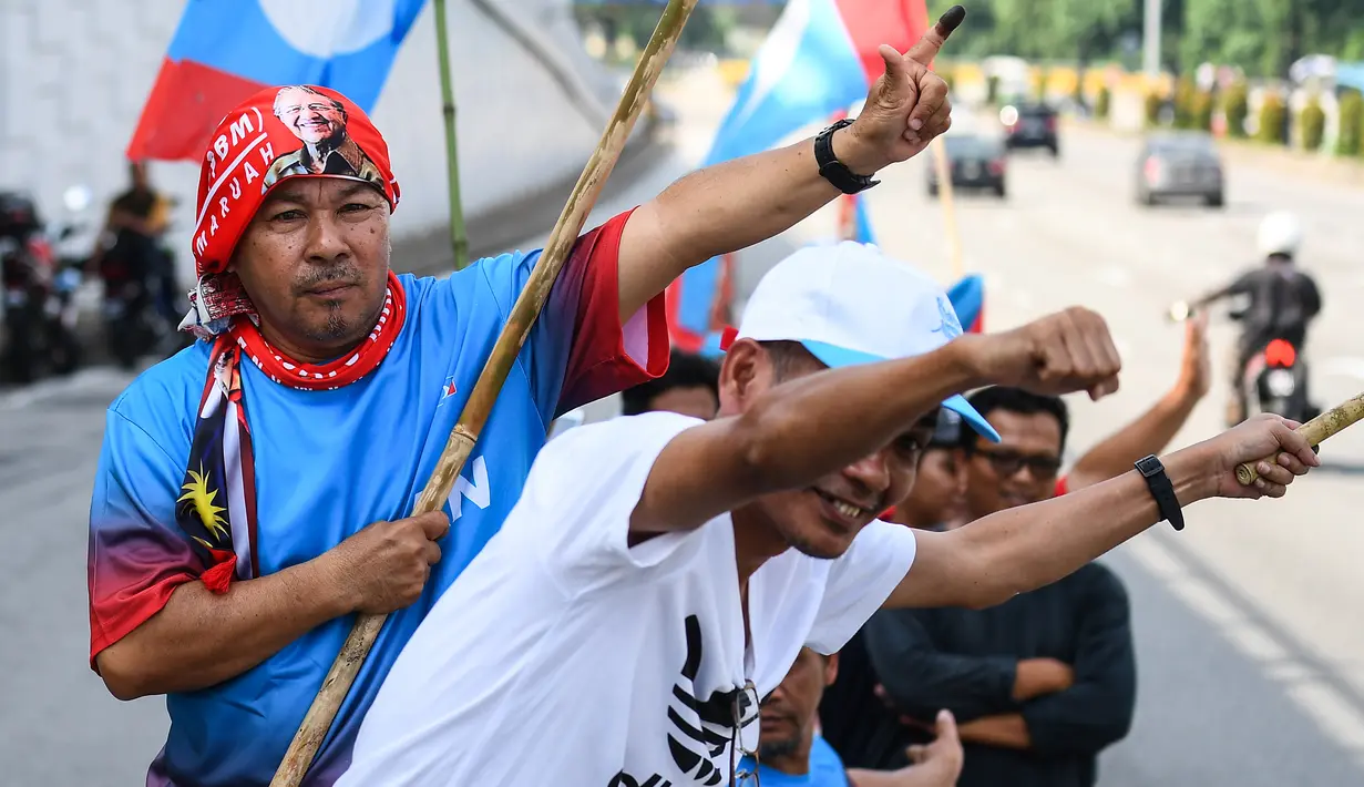 Pendukung Pakatan Harapan memadati jalan menuju Istana Negara menjelang pelantikan Mahathir Mohamad sebagai Perdana Menteri Malaysia di Kuala Lumpur, Kamis (10/5). Mahathir akan menjadi perdana menteri ketujuh Negeri Jiran. (AFP/Manan VATSYAYANA)