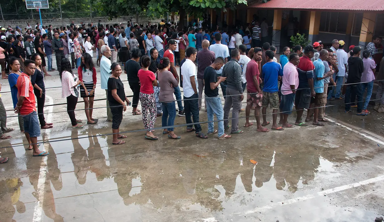 Warga Timor Leste mengantre untuk menggunakan hak pilih mereka di tempat pemungutan suara (TPS) di Dili, Senin (20/3). Sedikitnya 1,2 juta warga akan memilih presiden baru, menggantikan Presiden Taur Matan Ruak. (Valentino DARIEL SOUSA/AFP)