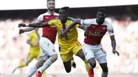 Aksi Wilfried Zaha yang kerap merepotkan pemain Arsenal pada laga lanjutan Premier League yang berlangsung di Stadion Emirates, Minggu (21/4). Arsenal kalah 2-3 kontra Crystal Palace. (AFP/Adrian Dennis)