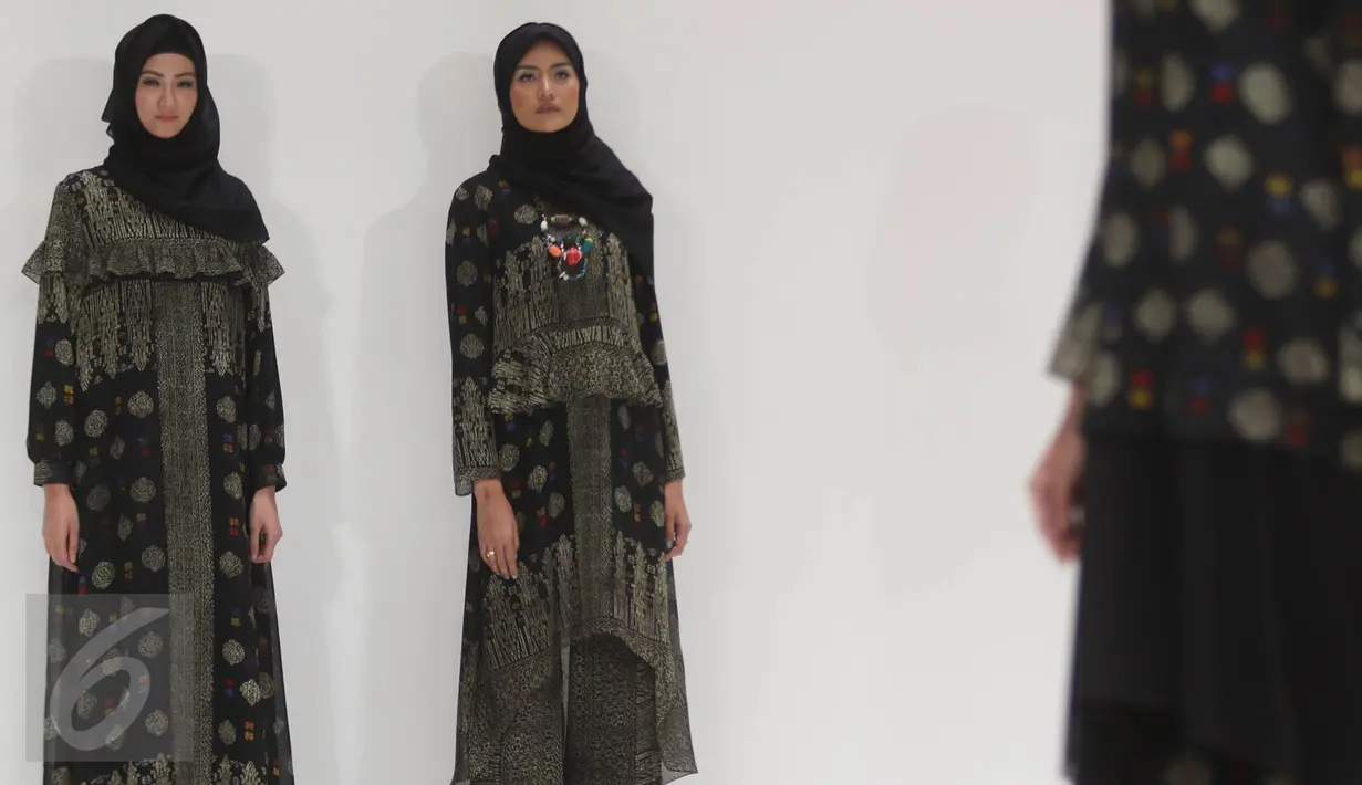 Model mengenakan busana karya desainer Itang Yunasz di Pasar Blok B Tanah Abang, Jakarta, Kamis (9/3). Dengan label Kamilaa, Itang menggunakan kain motif batik untuk gamis, kaftan, dan blus-blus panjang. (Liputan6.com/Immanuel Antonius)
