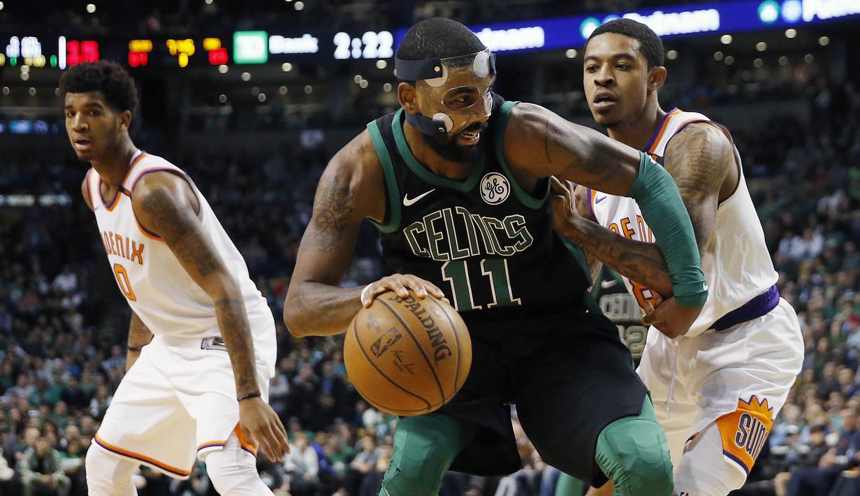 Pebasket Boston Celtics, Kyrie Irving, berusaha melewati pebasket Phoenix Suns, Tyler Ulis, pada laga NBA di Stadion TD Garden, Boston Minggu (3/12/2017). Boston Celtics menang 116-111 atas Phoenix Suns. (AP/Michael Dwyer)