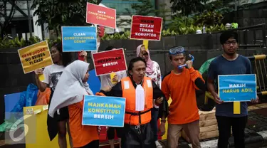 Sejumlah orang yang tergabung dalam Indonesia Corruption Watch (ICW) menggelar aksi teatrikal saat Car Free Day dikawasan Bunderan HI, Jakarta, Minggu (12/2). Aksi tersebut bertajuk 'Selamatkan Mahkamah Konstitusi'. (Liputan6.com/Faizal Fanani)