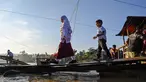 Sejumlah siswa menaiki perahu darurat untuk menyeberangi Sungai Peusangan pasca banjir bandang yang menghancurkan desa-desa di sekitarnya di kabupaten Bireuen, provinsi Aceh, Indonesia pada Senin 5 Januari 2026. Secara resmi, Dinas Pendidikan dan Kebudayaan (Disdikbud) Bireuen telah menetapkan jadwal masuk sekolah usai libur semester pada Senin (5/1/2025). (CHAIDEER MAHYUDDIN/AFP)