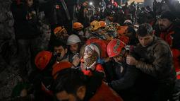 Seher, seorang wanita Suriah berusia 15 tahun yang diselamatkan oleh petugas penyelamat dari bawah reruntuhan dibawa ke ambulans di Hatay, Turki tenggara, pada 14 Februari 2023. Seher berhasil diselamatkan setelah terperangkap di bawah reruntuhan selama 210 jam seminggu setelah gempa mematikan melanda sebagian dari Turki dan Suriah. (AFP/Yasin AKGUL)