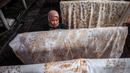 Seorang wanita mewarnai kain batik saat proses pembuatan di Sidoarjo, Jawa Timur, Sabtu (1/10/2022). Indonesia akan memperingati Hari Batik Nasional pada 2 Oktober. (JUNI KRISWANTO/AFP)