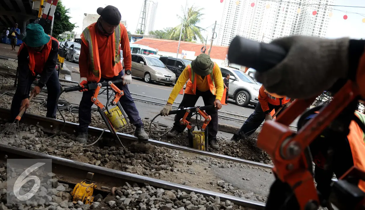 Pekerja menyelesaikan proses penggantian bantalan rel kereta api di kawasan Stasiun Karet, Jakarta, Rabu (28/12). Perawatan tersebut dilakukan untuk memperbaiki keseimbangan tinggi dan rendah rel kereta. (Liputan6.com/Gempur M. Surya)