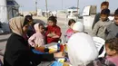 Inisiatif ini memberi ruang aman bagi mereka untuk menghadapi trauma akibat konflik berkepanjangan serta menuangkan ingatan mereka melalui seni lukis. Tampak dalam foto, anak-anak menyaksikan para perempuan muda melukis di pelabuhan Kota Gaza pada Kamis 12 Februari 2026. (Omar AL-QATTAA/AFP)