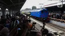 Warga menyaksikan rangkaian lokomotif listrik ESS 3200 tahun pembuatan 1927 saat memasuki peron pada perayaan 100 tahun operasional Kereta Rel Listrik (KRL) di Stasiun Jakarta Kota, Selasa (22/4/2025). (Liputan6.com/Angga Yuniar)