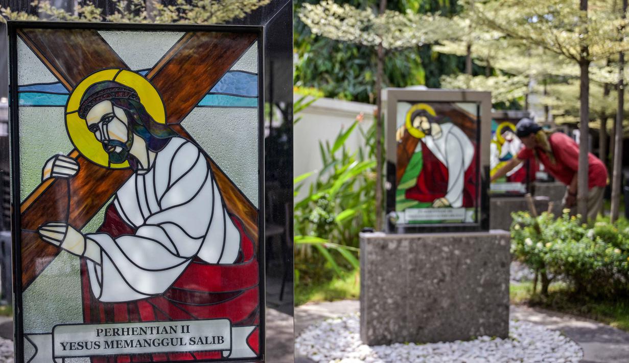 Misa Natal diartikan sebagai perayaan atau ibadah utama dalam kalender Gereja Kristiani, khususnya Umat Katolik. Tampak dalam foto, seorang pekerja membersihkan potret Yesus di Katedral Hati Kudus Yesus, yang dikenal secara lokal sebagai gereja "Hati Kudus Yesus", selama persiapan Misa Natal di Surabaya, Jawa Timur, pada Selasa 23 Desember 2025. (JUNI KRISWANTO/AFP)