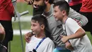 Gelandang Liverpool, Mohamed Salah foto bersama seorang anak tanpa memiliki kaki usai bermain selama sesi latihan jelang bertanding melawan Chelsea pada Piala Super Eropa 2019 di Stadion Taman Besiktas, di Istanbul (13/8/2019). (AP Photo/Lefteris Pitarakis)