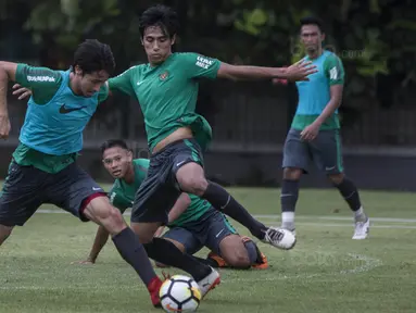 Pemain Timnas Indonesia, Gavin kwan Adsit, berusaha melewati Hanif Sjahbandi, saat latihan di Lapangan ABC Senayan, Jakarta, Senin (15/1/2018). Pemusatan latihan ini dilakukan jelang Asian Games 2018. (Bola.com/Vitalis Yogi Trisna)