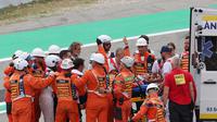 Pecco tampak diangkut ambulans. Informasi dari tayangan langsung MotoGP, Pecco dilarikan ke pusat medis. Namun, kabarnya Pecco masih sadarkan diri. Marshal juga memberikan acungan jempol ke kamera saat membawa Pecco ke ambulans. (AFP/Lluis Gene)