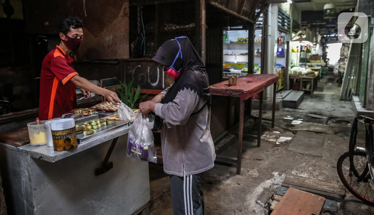 Pedagang kue melayani pembeli di Pasar Tradisonal Cempaka Putih, Jakarta, Kamis (11/6/2020). Pengelola pasar tradisional diwajibkan melaksanakan protokol kesehatan salah satunya dengan pembatasan jumlah konsumen hanya 50 persen kapasitas. (Liputan6.com/Faizal Fanani)