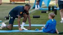 <p>Pemain Brasil, Neymar bercanda dengan putranya, Davi Lucca di sela sesi latihan di Sochi, Rusia, Jumat (29/6). Neymar mengajak putranya saat mengikuti latihan bersama Timnas Brasil di Piala Dunia 2018. (Adrian DENNIS/AFP)</p>