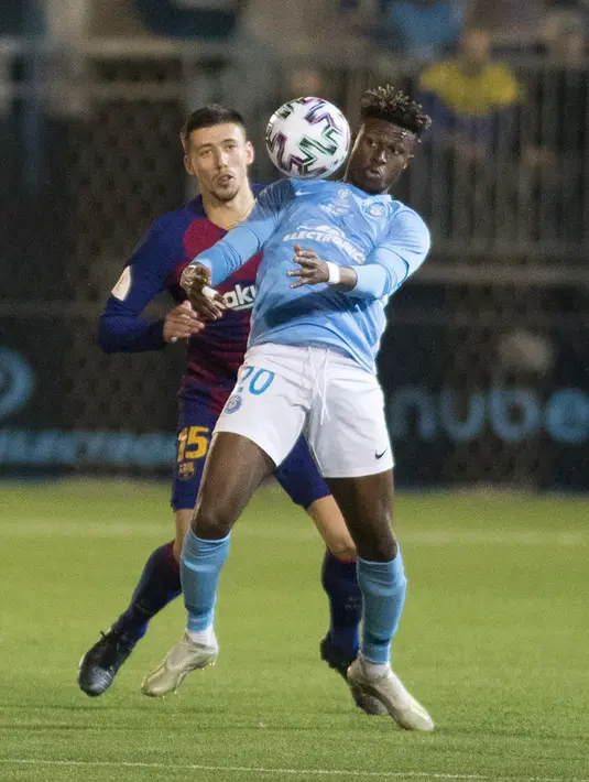 Bek Barcelona, Clement Lenglet (kiri) berebut bola dengan gelandang UD Ibiza, Kwasi Sibo pada pertandingan babak 32 besar Copa del Rey 2019-2020 di Estadi Municipal de Can Misses, Rabu (21/1/2020). Barcelona harus bersusah payah untuk mengalahkan Klub Segunda B UD Ibiza 2-1. (JAIME REINA/AFP)