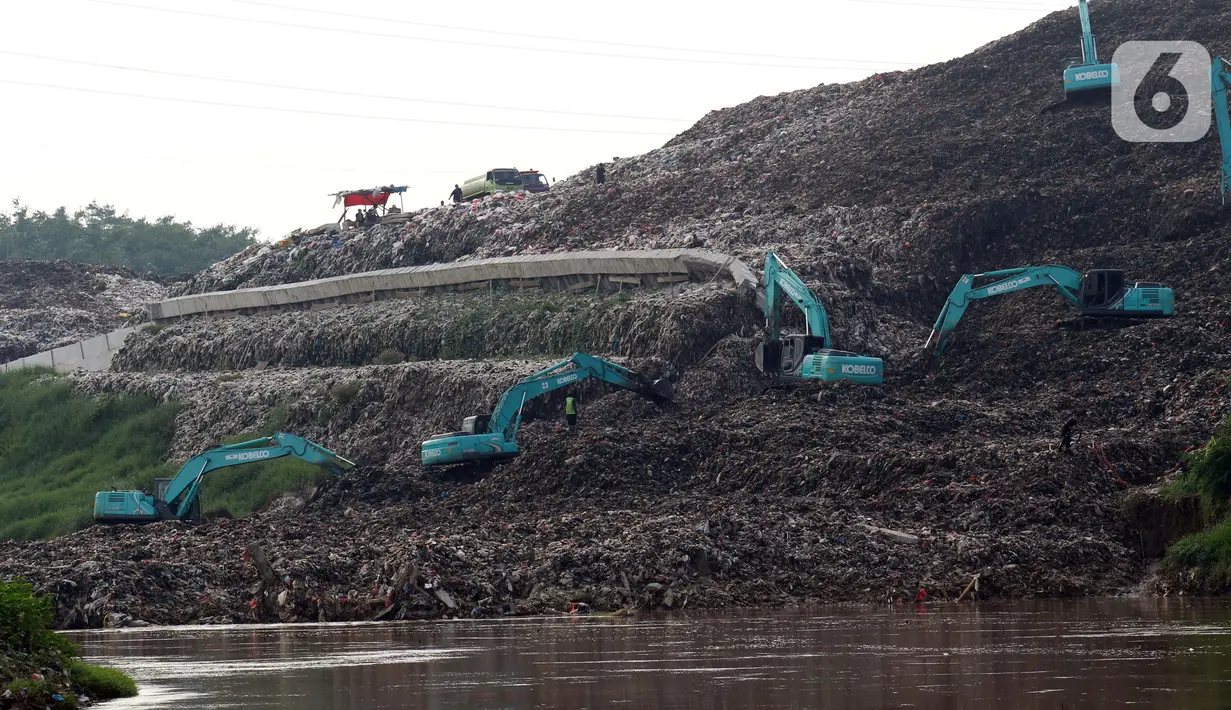 Beberapa alat berat dikerahkan untuk memindahkan tumpukan sampah dari Tempat Pembuangan Akhir (TPA) Cipeucang yang masuk ke area Sungai Cisadane, Serpong, Tangerang Selatan, Rabu (3/6/2020). Sebelumnya, pada Jumat (22/5/) lalu turap yang menopang TPA tersebut jebol. (Liputan6.com/Helmi Fithriansyah)