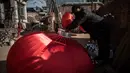 Seorang pekerja sedang merakit lampion merah yang akan dijual untuk menyambut perayaan Tahun Baru Imlek di provinsi Hebei, Tingkok (11/1). (AFP Photo/Fred Dufour)