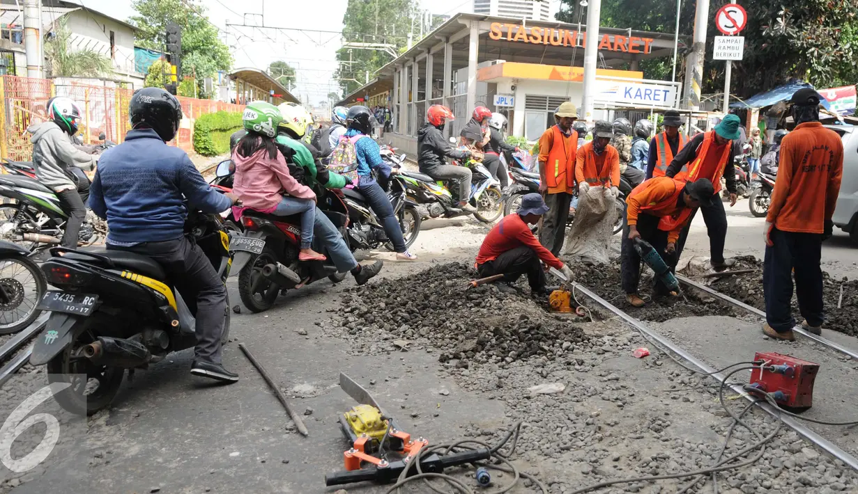 Antrean pengendara sepeda motor saat menyebrangi rel kereta api di kawasan Stasiun Karet, Jakarta, Rabu (28/12). Perawatan dan pengecekan rutin rel kereta api itu guna menjamin keselamatan perjalanan kereta api. (Liputan6.com/Gempur M. Surya)