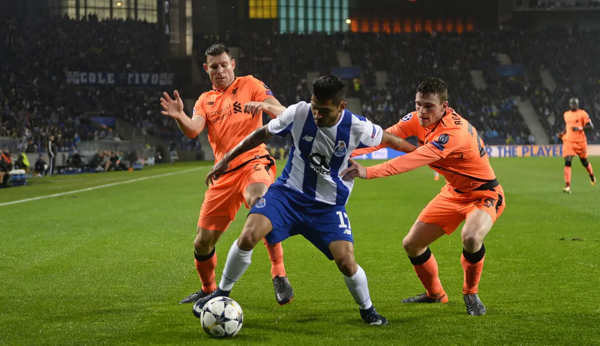 Penyerang FC Porto Porto, Jesus Corona berebut bola dengan pemain Liverpool James Milner dan Andrew Robertson dalam leg pertama babak 16 besar Liga Champions di Stadion Do Dragao, Kamis (15/2). Liverpool menundukkan Porto dengan skor 5-0. (AP/Luis Vieira)