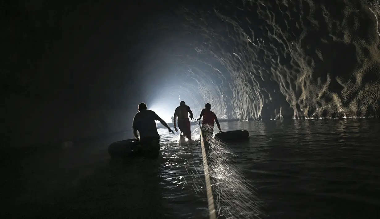 Sejumlah warga menyusuri terowongan saat akan memperbaiki sistem air yang mereka buat di Caracas, Venezuela, Kamis (11/6/2020). Tanpa air minum dari otoritas pemerintah, penduduk Esperanza mengumpulkan air dari dalam terowongan jalan raya Baralt yang tidak pernah selesai. (AP Photo/Matias Delacroix)