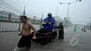 Seorang pengendara motor menggunakan jasa gerobak dorong untuk melewati banjir yang menggenangi jalan Gunung Sahari, Jakarta, Senin (9/2/2015).  (Liputan6.com/Faizal Fanani)