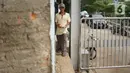 Warga memanfaatkan celah pagar untuk melintasi gerbang jalur inspeksi Sungai Ciliwung yang ditutup di kawasan Kampung Melayu, Jakarta, Selasa (14/7/2020). Penutupan tersebut dilakukan untuk membatasi mobilitas warga sehingga dapat meminimalisasi penyebaran COVID-19. (Liputan6.com/Immanuel Antonius)