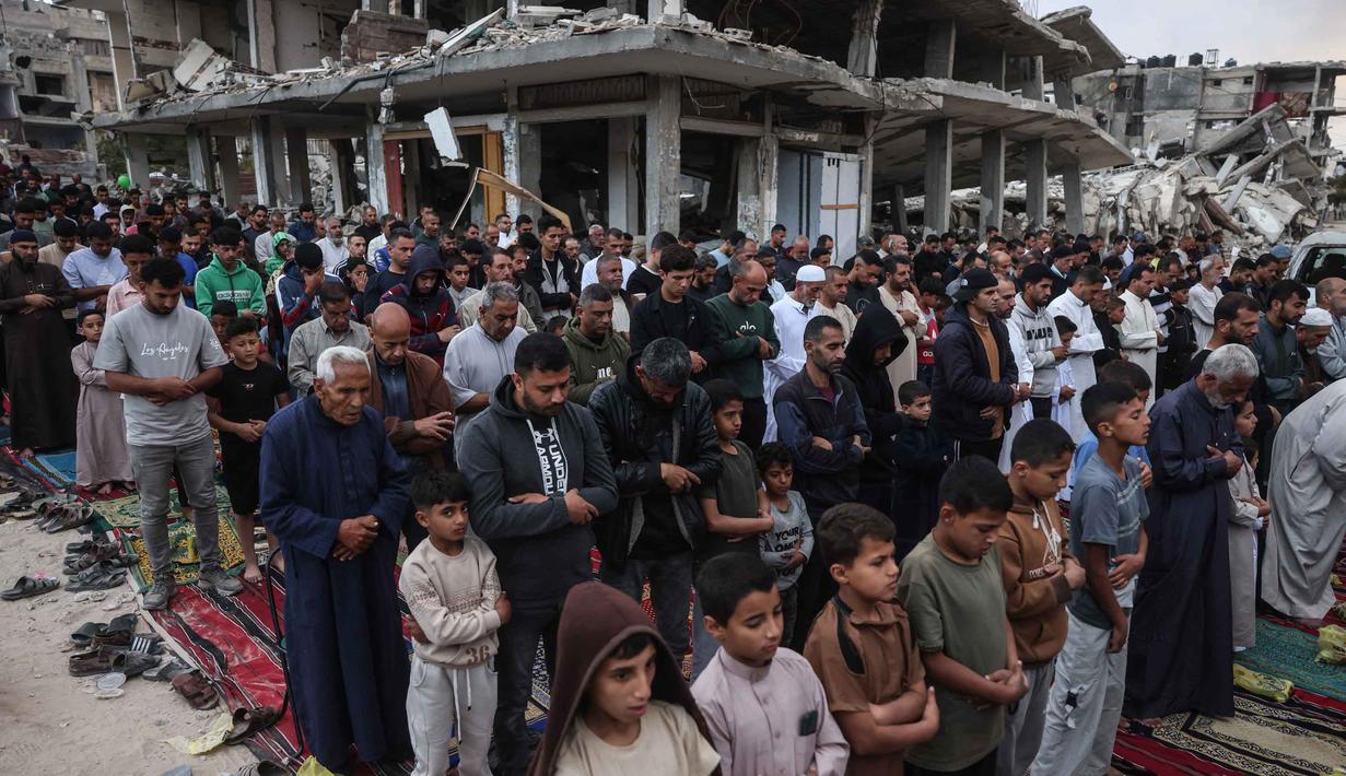 Warga Palestina melaksanakan salat menandai dimulainya Idul Adha, Hari Raya Kurban, di jalan yang rusak parah di Khan Yunis, Jalur Gaza Selatan, pada Rabu 27 Mei 2026. (BASHAR TALEB/AFP)