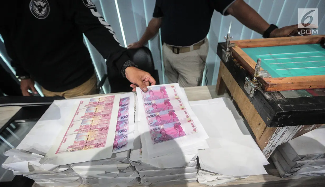 Barang bukti diperlihatkan saat rilis oleh Direktorat Tindak Pidana Ekonomi Khusus Bareskrim Polri di Jakarta, Rabu (18/10). Dalam rilis tersebut Bareskrim berhasil menangkap enam pelaku jaringan pengedar uang palsu. (Liputan6.com/Faizal Fanani)