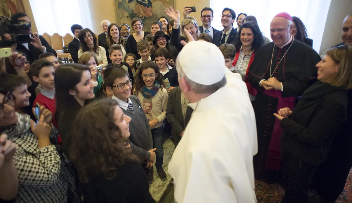 Paus Fransiskus menyapa kelompok pemuda Italian Catholic Action di Vatikan, Kamis (17/12/2015). Anggota Italian Catholic Action memberikan kejutan kue ulang tahun untuk Paus Fransiskus yang berulang tahun ke-79. (REUTERS/Osservatore Romano)