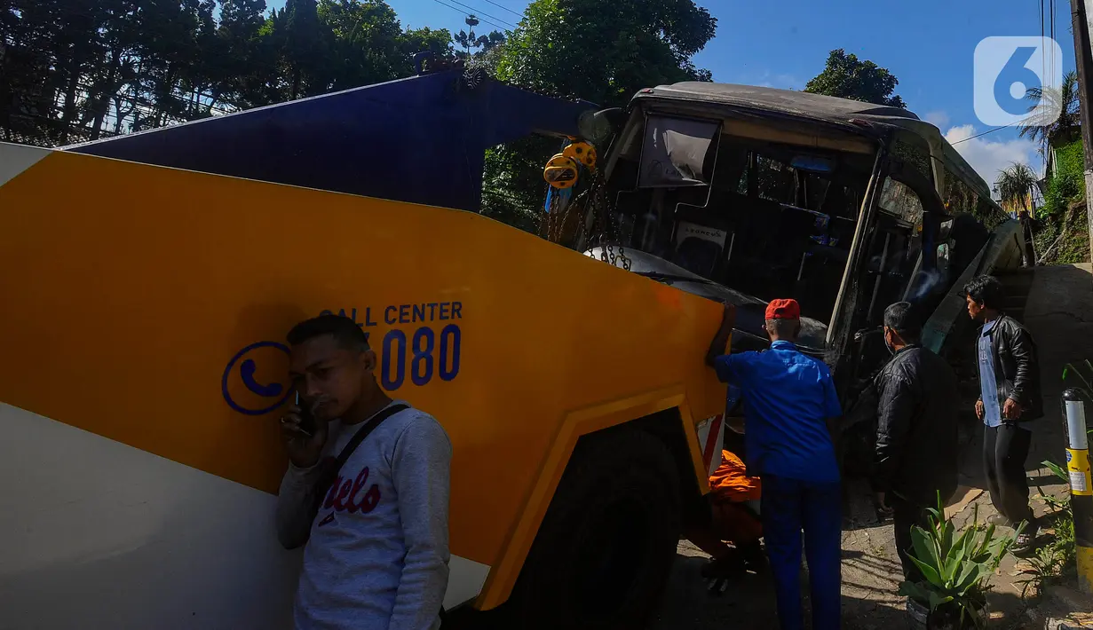 Petugas mengevakuasi bus AKAP trayek Tasikmalaya-Jakarta yang mengalami kecelakaan menabrak tembok pembatas jalan di kawasan Cisarua, Bogor, Rabu (28/6/2023). (merdeka.com/Arie Basuki)
