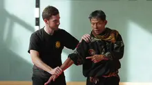Haji Sofyan Nadar menunjukkan cara melepaskan diri dari genggaman dua murid Anak Harimau. (Bola.com/Reza Khomaini)