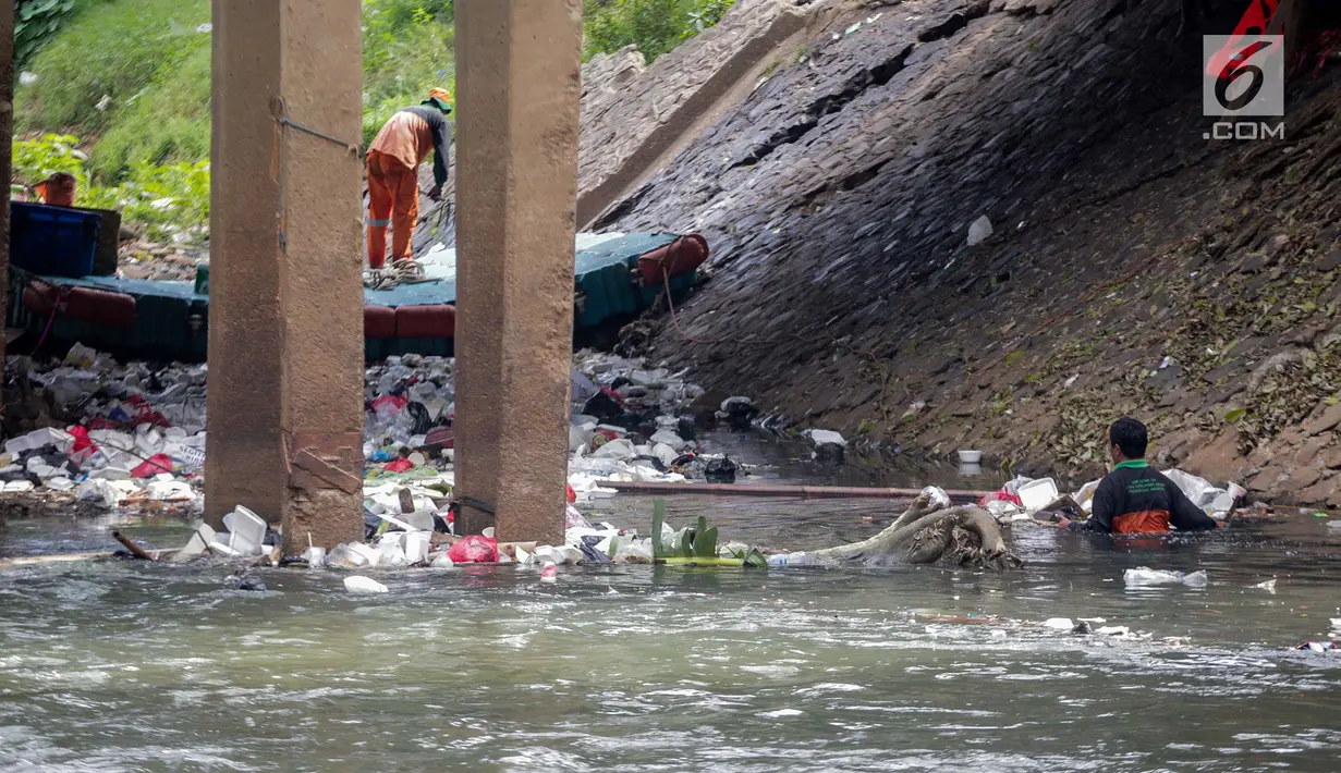 Petugas PPSU saat membersihkan tumpukan sampah yang tersangkut  di aliran anak kali Ciliwung, Jakarta, Senin (22/7/2019). Pembersihan sungai dari berbagai sampah tersebut dimaksudkan agar tidak ada penumpukan sampah dan sedimentasi saluran di sepanjang sungai. (Liputan6.com/Faizal Fanani)