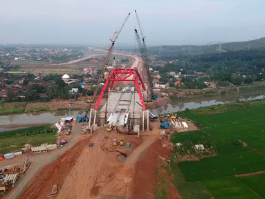 Foto udara pengerjaan Jembatan Kalikuto di Gringsing, Kabupaten Batang, Jawa Tengah, Senin (11/6). Menteri PUPR Basuki Hadimuljono mengatakan, jembatan pelengkung baja ini merupakan pertama di Indonesia. (Liputan6.com/Arya Manggala)