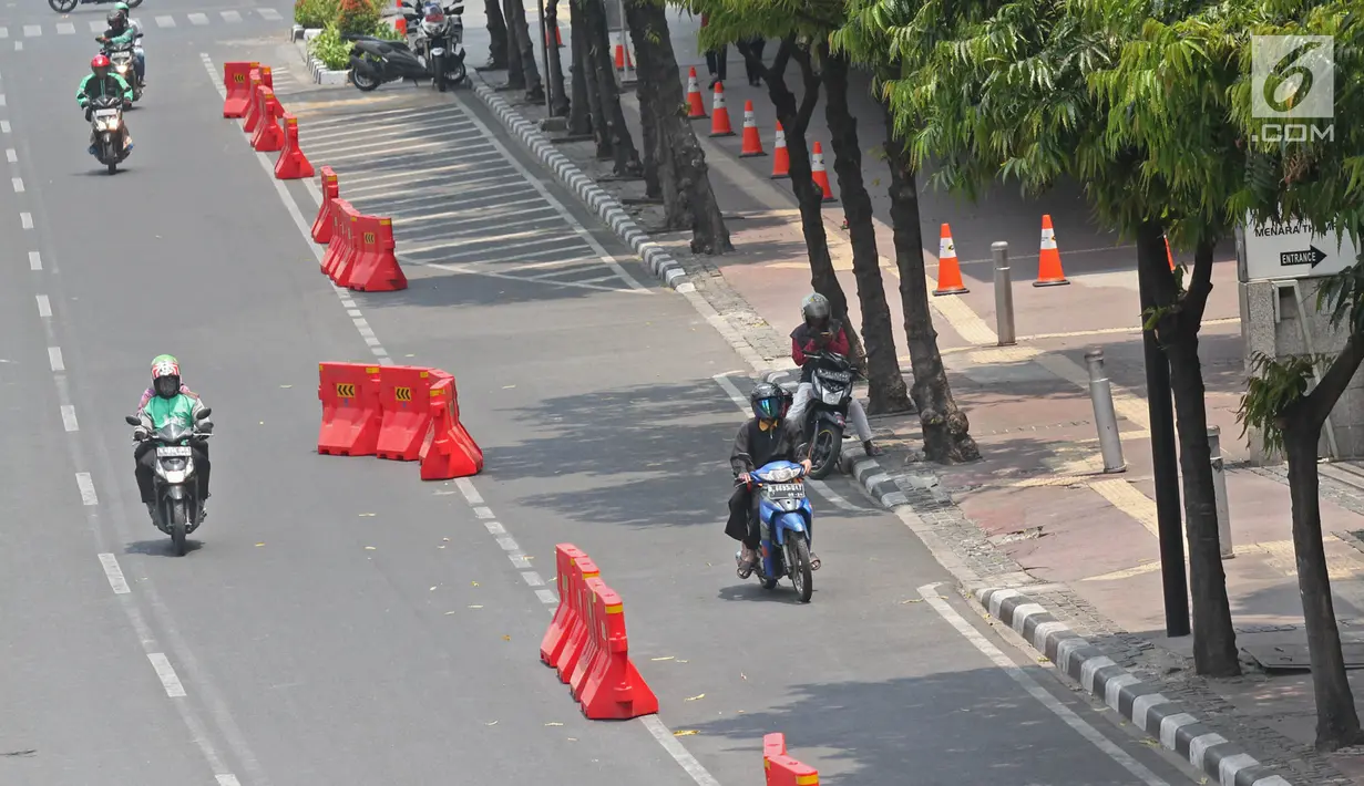 Pengendara sepeda motor melintasi jalur sepeda di Jalan MH Thamrin, Jakarta, Selasa (24/9/2019). Dishub DKI Jakarta bekerja sama dengan Polda Metro Jaya akan menilang pengendara kendaraan bermotor yang melintas atau berhenti di jalur sepeda mulai 20 November 2019. (Liputan6.com/Herman Zakharia)