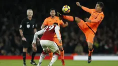 Gelandang Liverpool, Roberto Firmino, berebut bola dengan gelandang Arsenal, Granit Xhaka, pada laga Premier League di Stadion Emirates, London, Jumat (22/12/2017). Kedua klub bermain imbang 2-2. (AFP/Ian Kington)