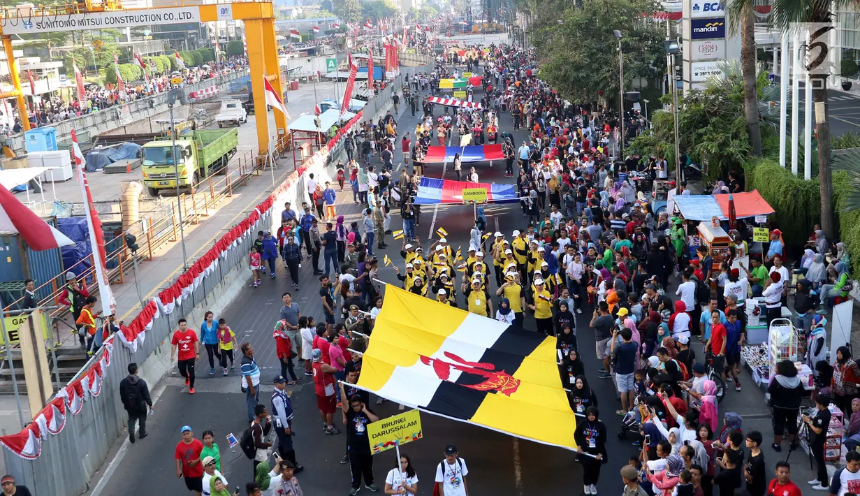 Peserta membentangkan bendera negara anggota ASEAN saat parade ASEAN 50 Tahun di Jakarta, Minggu (27/8). Acara ini merupakan pertunjukan keragaman budaya di Asia Tenggara yang bersatu guna memperingati 50 tahun ASEAN berdiri. (Liputan6.com/Angga Yuniar)