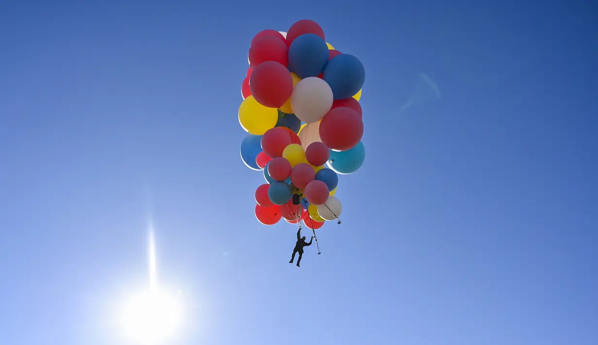 David Blaine terbang dengan memegang balon helium saat melakukan aksi "Ascension" di Page, Arizona, Amerika Serikat, Rabu (2/9/2020). David Blaine berhasil melakukan aksi ekstrem tersebut dengan terbang setinggi 7.600 meter. (David Becker/GETTY IMAGES NORTH AMERICA/Getty Images via AFP)