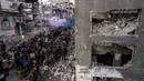 Mereka terpaksa berbuka puasa di sekitar reruntuhan bangunan permukiman yang runtuh akibat perang antara Israel dan Hamas. (Bashar TALEB/AFP)