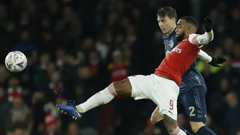 Striker Arsenal, Alexandre Lacazette, berusaha melewati bek Manchester United, Victor Lindelof. (AFP/Ian Kington)