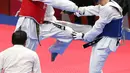 Atlet taekwondo Indonesia, Ibrahim Zarman bertarung melawan Gangmin Cho asal Korea Selatan di kelas putra under 63 Kg di lapangan taekwondo JCC, Jakarta, Rabu (22/8). Ibrahim gagal melaju ke semifinal. (Liputan6.com/Fery Pradolo)